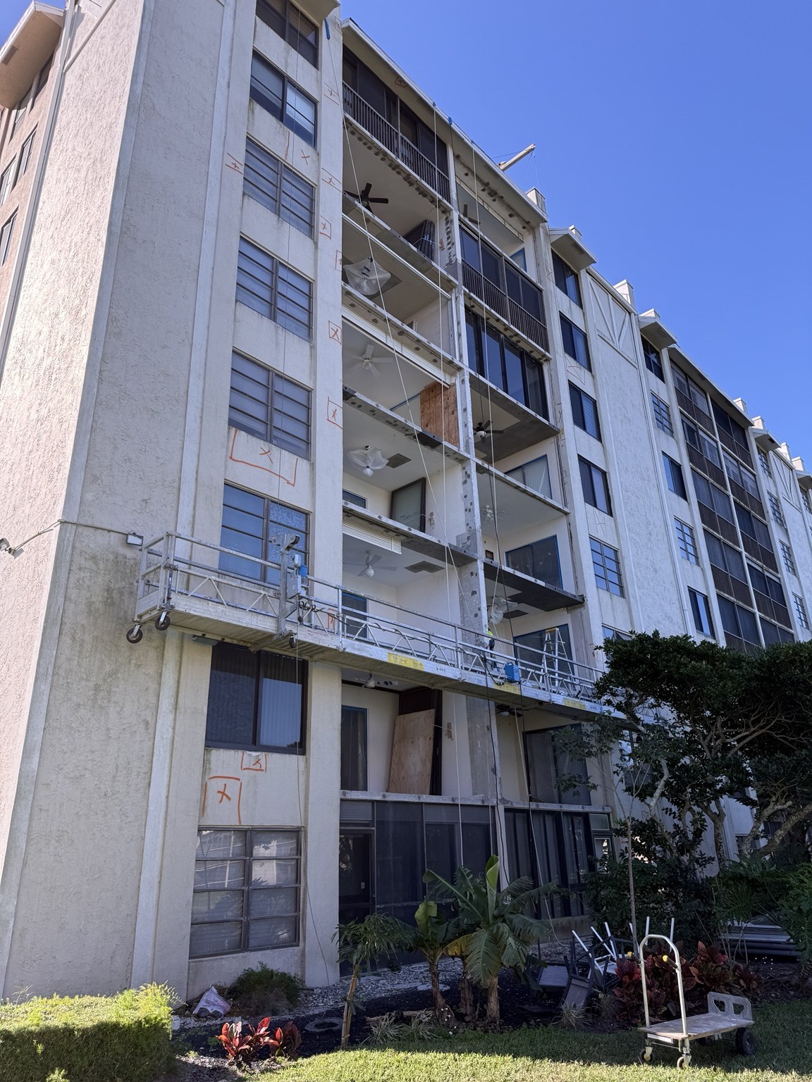 Exterior restoration in progress on a multistory residential building with scaffolding